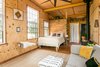 Modern home with Bedroom, Medium Hardwood Floor, Table Lighting, Storage, Bed, Ceiling Lighting, and Chair. Our cabin has 10 foot ceilings which help the space feel big and expansive. Photo of Off Grid Cabin in the Texas Hill Country