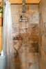 Modern home with Bath Room, Pendant Lighting, Porcelain Tile Wall, Corner Shower, Medium Hardwood Floor, and One Piece Toilet. The shower has amazing water pressure and the rock floor is a bonus! Photo 6 of Off Grid Cabin in the Texas Hill Country