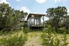 Modern home with Outdoor, Grass, Trees, Front Yard, Decking Patio, Porch, Deck, and Small Patio, Porch, Deck. Our cabin is nestled in the middle of the woods, with our own cabin just a stone's throw away. Photo 9 of Off Grid Cabin in the Texas Hill Country