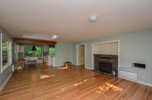 Before: The main living space was large, but cut off from the kitchen by a wall and featured a dated fireplace.