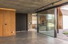 Modern home with Doors and Interior. The board-formed concrete is sovereign on the residence. Made in an experimental way by the construction team, the client approved the quality of a wall prototype made in the beginning of the construction, being adopted later as coating for the whole house: walls, ceiling, flooring, all elements apparent and definitive. Once the mold was removed, only the treatment of the material by a specialized team remained. It does not require maintenance, painting, gypsum ceiling, roughcast, plaster, nothing. It is ready as soon as it is unmold. Photo 10 of Patio House