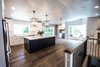 Modern home with Kitchen, Subway Tile Backsplashe, Vinyl Floor, White Cabinet, Engineered Quartz Counter, Pendant Lighting, Ceiling Lighting, Colorful Cabinet, Beverage Center, and Wood Cabinet. Kitchen Photo of Limoncello