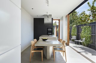 The kitchen/dining space is oriented sideways, making the most of the narrow site and opening out onto the rear courtyard to create an indoor/outdoor living space.