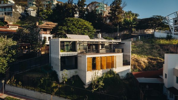 Casa Comiteco is located on a corner site with a steep decline close to the protected Serra do Curral area, which is known for beautiful mountain views.