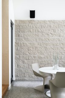 The stone feature wall in the living/dining area is constructed from Adbri Masonry architectural brick in ivory. The floor is polished concrete with an aggregate mix of stones that resemble the colors of the blocks in the feature wall.