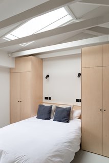 To make space for the new hallway, the existing master bedroom had to be reduced in size. To make efficient use of the smaller space, BVDS Architecture designed fitted wardrobes either side and over the double bed. An existing flat ceiling was also removed to open up the space and create more volume.