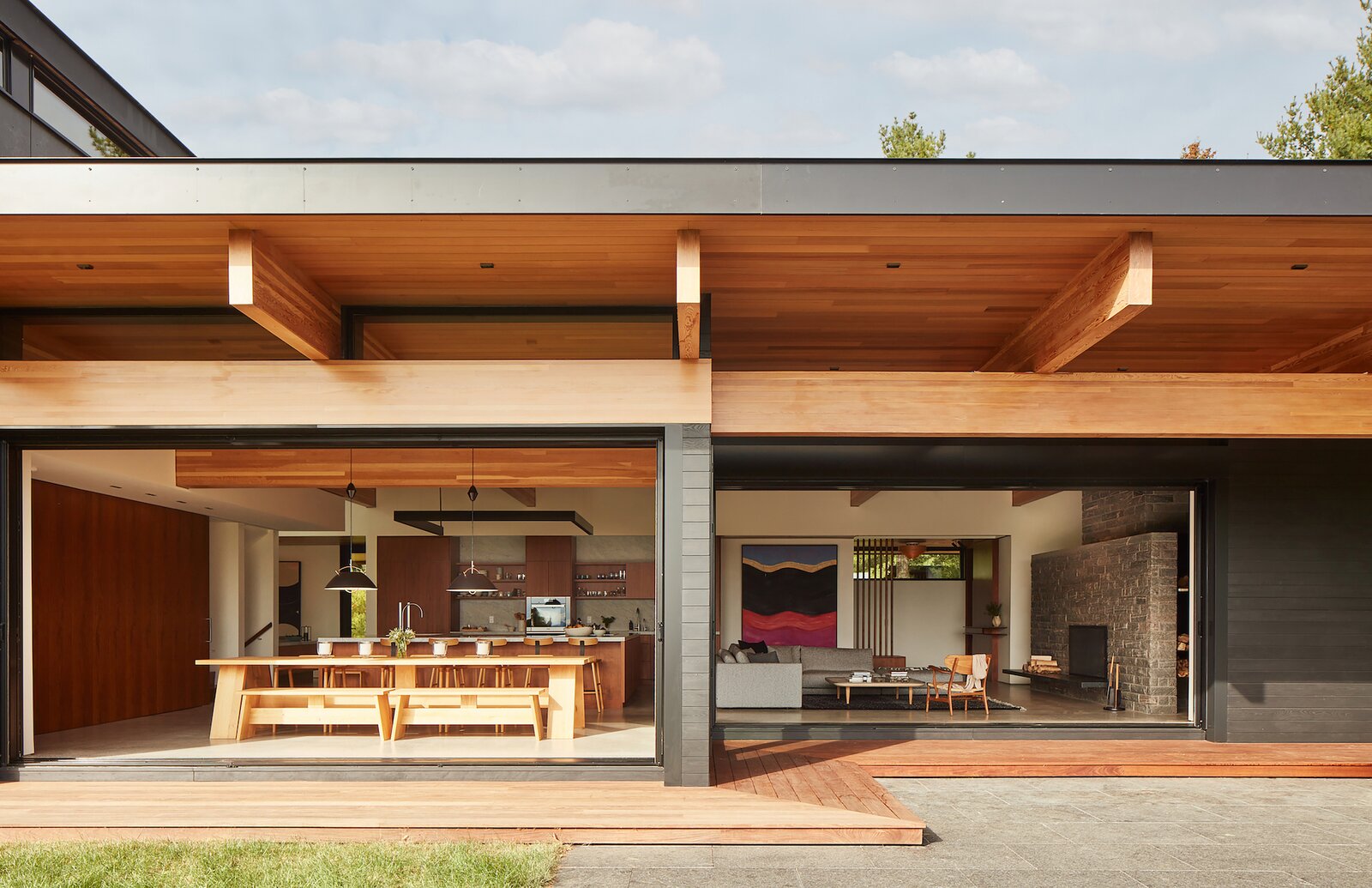 Operable floor-to-ceiling glass doors slide into pockets to open the entire great room—including living and dining areas—to the outdoors. 