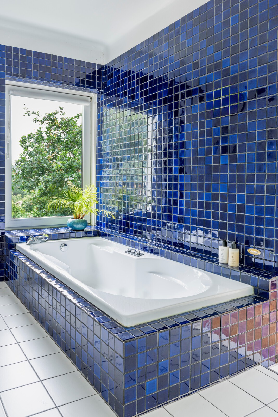 <span style="font-family: Theinhardt, -apple-system, BlinkMacSystemFont, &quot;Segoe UI&quot;, Roboto, Oxygen-Sans, Ubuntu, Cantarell, &quot;Helvetica Neue&quot;, sans-serif;">The blue tiles and Jacuzzi bath were a 1980's addition to the home. Catherine and Dermot loved them, and so renovated the entire bathroom around the bathtub and tiles. "We just didn't think there was any point in changing something we liked so much,