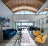 Modern home with Living Room, Coffee Tables, Chair, Concrete Floor, Sofa, Bookcase, and Recessed Lighting. Southern yellow pine glulam beams create the foundation for the curved ceiling that provides space for the clerestory windows which make for light and shadow play throughout the day. Photo 3 of The Schechter House