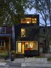 Modern home with Exterior, House Building Type, Shingles Roof Material, and Wood Siding Material. The all-black exterior cladding creates a quiet pause in the streetscape. By day, it acts as an abstract canvas for shadow play from the boulevard trees. By night, it has the quality of an austere lantern. Photo 2 of Bellwoods Lodge