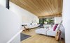 Modern home with Living Room, Medium Hardwood Floor, Slate Floor, Chair, Sectional, Wood Burning Fireplace, and Coffee Tables. The sloped living room ceiling creates an intimate compression at the low end - a delightful spot to read within the tree tops, or enjoy snow falling on the street below. Photo 7 of Bellwoods Lodge