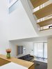 Modern home with Staircase and Wood Tread. Stepping down into the intimate library area, overlooked from the kitchen, and with a view up into the light well. Above, a clerestory glass panel in the second floor washroom floods it with daylight. The split level condition with open stairs provides views through multiple levels as one circulates throughout the home. Photo 9 of Bellwoods Lodge