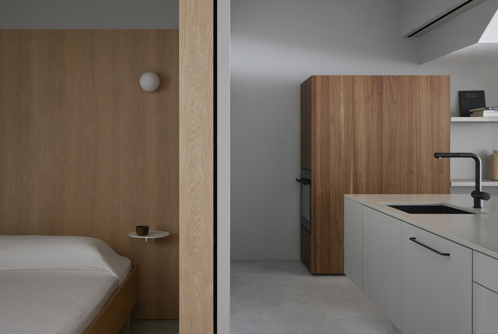 The guest room on the left can be closed up with a sliding door; in the dry kitchen, blockish joinery contain appliances and kitchen storage. 