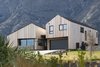 Modern home with Exterior, Wood Siding Material, House Building Type, Gable RoofLine, and Metal Roof Material. "In response to the brief and the tapered shape of the site, we started off with two
pavilions that ran parallel to the northern and southern boundaries. This approach
resulted in an overlap of both structures. The intersecting part of the north wing
was sliced off and made space for the central entrance and foyer. This naturally
developed roof form is a contextual response to the outstanding alpine landscape" Daniel says. Photo of Twin Peak House