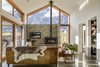 Modern home with Living Room, Coffee Tables, Ceiling Lighting, Sofa, Concrete Floor, and Wood Burning Fireplace. "Schist is a traditional material that dominates the region. It also has great thermal mass
properties, so it made sense to embed the fireplace into the schist feature
wall in the living area. As this wall is facing ‘The Remarkables’ mountain range, there had to be a
visual connection to the mountain peak behind it and the sky above. We
concluded that using a schist wall at the base of this window would further
enhance the sense of connection and create a space that is in tune with its wider
environment." Photo 5 of Twin Peak House