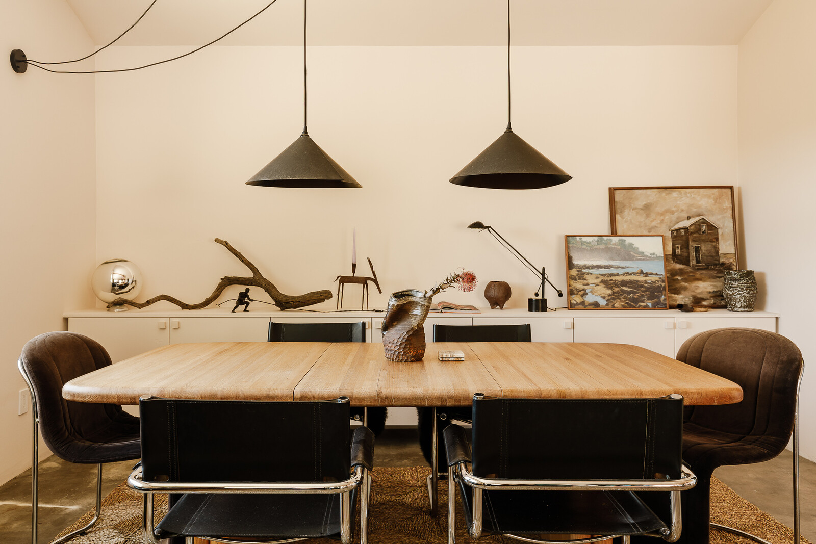 The dining table is vintage solid oak from Vintage on Point. The chairs are vintage chrome and maroon velvet from Vintage on Point, and black leather metal frame cantilever chairs sourced from Palm Springs Flea Market.