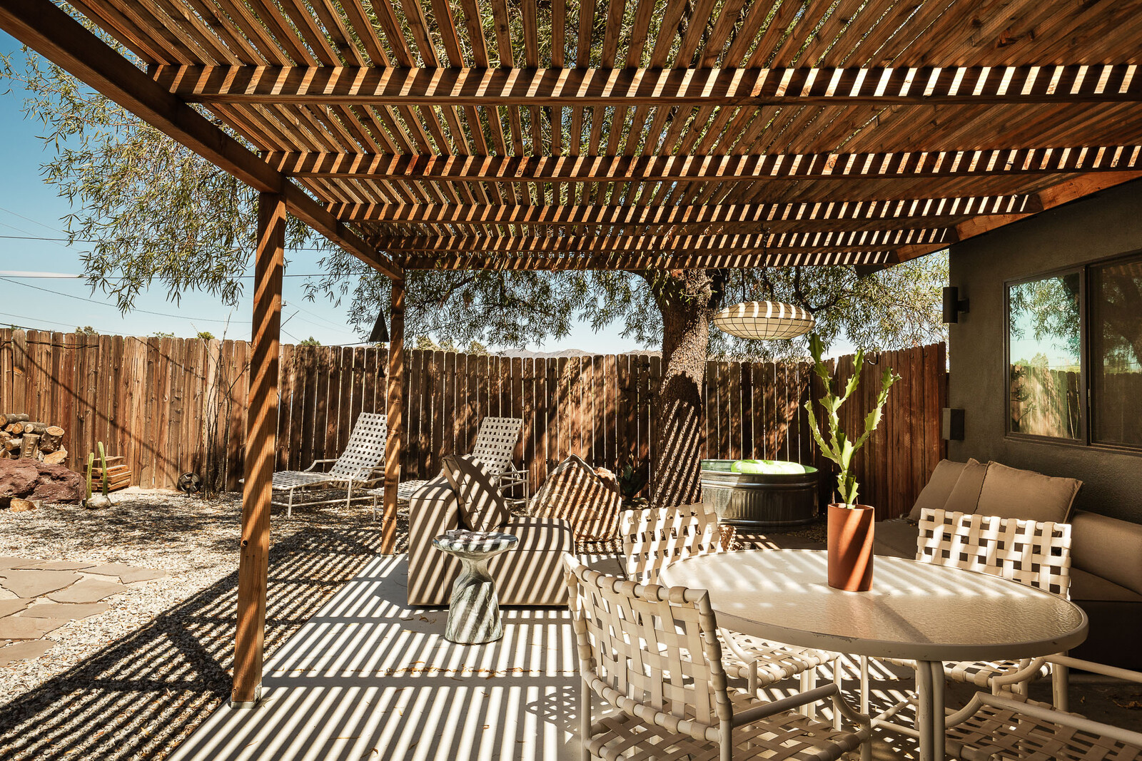 The outdoor sofa is from Room and Board, and the loungers and dining set are vintage.