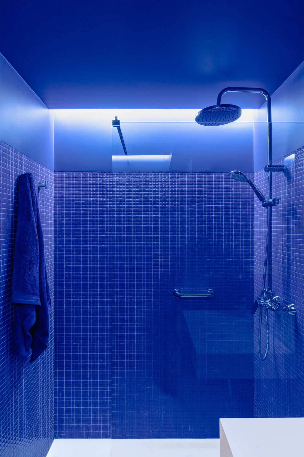 Manzano made the decision to clad the bathroom off the entry hallway in blue, offering a theatrical escape from the rest of the apartment. "This bathroom is very tight, so we thought, let's just do one thing and try to make it a relaxing space."