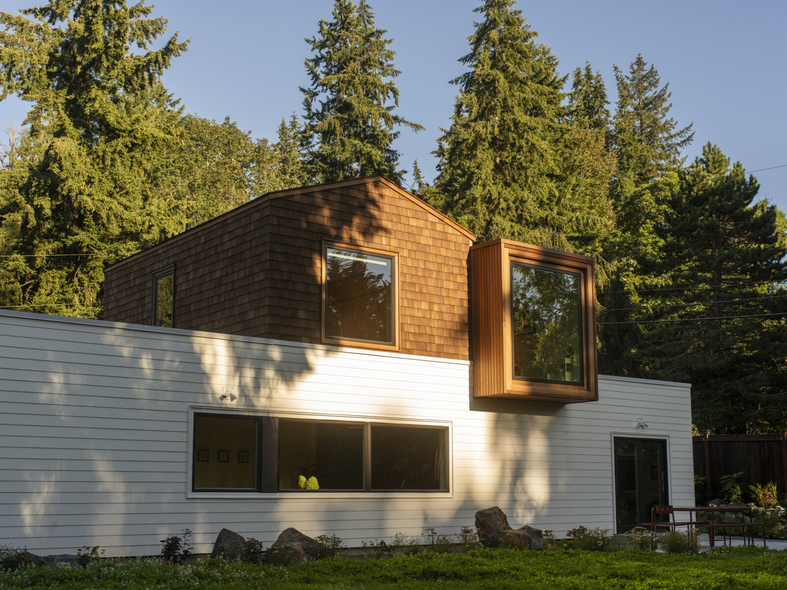 A sliding door connects the kitchen to a new outdoor dining area and the lawn beyond.