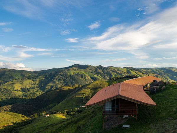 Arquipélago Arquitetos and Mariana Caires designed this timber home hugging the hillside in the Bocaina countryside region of Brazil.