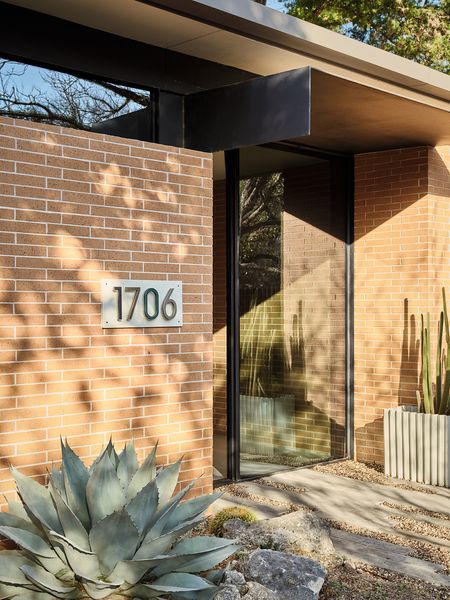 The house embraces a warm brick exterior to help it blend into the neighborhood, which features many midcentury homes.