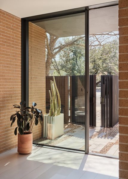 The glass-framed entrance sees the exterior brick continue from outside to inside.
