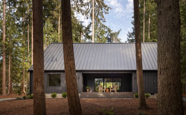 The cabin is clad in budget-friendly Hardie in a board and batten pattern, painted in Benjamin Moore's Iron Ore.