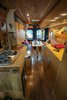 Modern home with Kitchen, Wood Counter, Wood Backsplashe, Ceiling Lighting, Refrigerator, Wood Cabinet, Dark Hardwood Floor, and Drop In Sink. A hidden composting toilet as well as laundry and bathroom storage are underneath the right side butcher block counter top. Photo 6 of The Pennybago