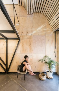 The mirrored "vault" not only reflects natural light into the interior, but also conceals an air conditioning unit, which needed a ventilated space to properly work. The lower part of the vault can be opened like a trapdoor for access. 