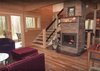 Modern home with Living Room, Sectional, Track Lighting, Light Hardwood Floor, and Gas Burning Fireplace. Living Room, Fireplace, Stairs. All open onto the Sunspace in the AQ-1 by Enertia® Photo 3 of Aquarius 1 Mass Timber Geo-Solar home by Enertia®