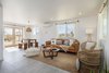 Modern home with Living Room, Floor Lighting, Sofa, End Tables, Porcelain Tile Floor, Coffee Tables, Pendant Lighting, Recessed Lighting, Chair, and Ceiling Lighting. After: Spacious Living Room Photo 6 of Mojave Mesa House
