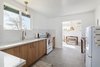 Modern home with Kitchen, Porcelain Tile Floor, Wood Cabinet, Dishwasher, Recessed Lighting, Microwave, Ceramic Tile Backsplashe, Ceiling Lighting, Range, Engineered Quartz Counter, Pendant Lighting, Undermount Sink, and Refrigerator. After: The Kitchen Photo 10 of Mojave Mesa House