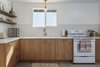 Modern home with Kitchen, Engineered Quartz Counter, Ceiling Lighting, Dishwasher, Refrigerator, Pendant Lighting, Porcelain Tile Floor, Microwave, Range, Undermount Sink, Wood Cabinet, Ceramic Tile Backsplashe, and Recessed Lighting. After: The Kitchen Photo 11 of Mojave Mesa House