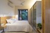 Modern home with Bedroom, Light Hardwood Floor, Bed, Wardrobe, Wall Lighting, Accent Lighting, Concrete Floor, Dresser, Storage, Ceiling Lighting, Bench, and Porcelain Tile Floor. designed by Estúdio Minke Photo 8 of Casa da Pedra (The stone house)