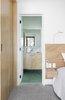 Modern home with Bath Room, Marble Counter, Porcelain Tile Wall, Ceiling Lighting, Floor Lighting, Drop In Sink, Ceramic Tile Wall, Stone Tile Wall, Light Hardwood Floor, and Open Shower. designed by Estúdio Minke Photo 10 of Casa da Pedra (The stone house)