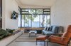 Modern home with Living Room, Wall Lighting, Chair, Recliner, Lamps, Sofa, Ceramic Tile Floor, Porcelain Tile Floor, Bench, and Ceiling Lighting. designed by Estúdio Minke Photo 15 of Casa da Pedra (The stone house)
