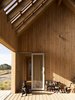 Modern home with Outdoor, Wood Patio, Porch, Deck, Back Yard, Large Patio, Porch, Deck, Decking Patio, Porch, Deck, Garden, Side Yard, Small Patio, Porch, Deck, Walkways, Field, Trees, Vertical Fences, Wall, Wood Fences, Wall, and Front Yard. Carefully proportioned, the simple gable form is reminiscent of a humble Tramper's Hut externally lined with Abodo Tundra Timber Cladding that is sustainably and locally grown and sourced. Photo 3 of Karangahake House