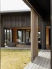 Modern home with Exterior, House Building Type, Beach House Building Type, Butterfly RoofLine, Wood Siding Material, Metal Roof Material, and Shed RoofLine. The surrounding land is cloaked with local Kanuka trees, a dark bark of the Mangawhai Peninsula, mimicked by the exterior dark stained ply cladding and cedar timber slatting rhythmically sequenced – as if the house is the architectural imagination of the surrounding forest’s collective heartbeat. Photo 2 of The Crest House