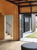 Modern home with Living Room, Medium Hardwood Floor, Ottomans, Stools, Painted Wood Floor, Light Hardwood Floor, Plywood Floor, Ceiling Lighting, Bench, and Chair. Boundaries no longer exist when spaces flow freely between inside and outside, the house breathes openly together with its landscape, with only the warm plywood lined interiors acting as a signifier. Photo 5 of The Crest House