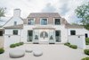 Modern home with Exterior, House Building Type, Farmhouse Building Type, and Stucco Siding Material. Home exterior features white stucco, cedar wood trim, custom black window frames and handmade front door from Poland. Photo of Beautiful Belgian-inspired Farmhouse