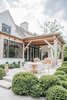 Modern home with Outdoor, Back Yard, Concrete Patio, Porch, Deck, Trees, Large Patio, Porch, Deck, Gardens, Landscape Lighting, Grass, Shrubs, Garden, Planters Patio, Porch, Deck, and Walkways. The indoor outdoor living is defined by large steel and glass doors that open to a covered barbecue area. The natural wood and white finishes are an extension of the home's interior design. Photo 10 of Beautiful Belgian-inspired Farmhouse
