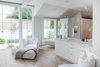 Modern home with Bath Room, Recessed Lighting, Marble Counter, Stone Slab Wall, Ceiling Lighting, Open Shower, Marble Wall, Drop In Sink, Light Hardwood Floor, and Freestanding Tub. The master bedroom opens up to the master bath and closet area. Photo 8 of Beautiful Belgian-inspired Farmhouse