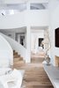 Modern home with Staircase, Wood Railing, and Wood Tread. Natural light, vaulted ceilings, bright white walls and furniture creates an airy yet welcoming space. Photo 4 of Beautiful Belgian-inspired Farmhouse
