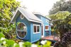 Modern home with Exterior, Beach House Building Type, Farmhouse Building Type, Wood Siding Material, Metal Roof Material, Curved RoofLine, Shed Building Type, A-Frame RoofLine, Cabin Building Type, and House Building Type. Oasis Tiny House, clad in teal-painted plywood and a metal roof that's pitched in the front and curved in the rear, was designed and built by Ellie and Dan Madsen of Paradise Tiny Homes in Keaau, Hawaii. Photo of Paradise Tiny Home