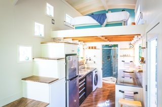 The curved portion of the roof provides added headspace for the loft-style bedroom. "I really like the bubble windows along the storage stairs," Dan says. "They match the curvy aspects of the house, and you can put your head inside them and see 180 degrees."