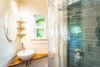 Modern home with Bath Room, Wood Counter, Track Lighting, Corner Shower, Enclosed Shower, Ceramic Tile Wall, Glass Tile Wall, Accent Lighting, Ceiling Lighting, Porcelain Tile Wall, Vessel Sink, Full Shower, Wall Lighting, Open Shower, and Subway Tile Wall. A Hawaiian mango wood counter and shelving add texture and warmth in the bathroom. Photo 7 of Paradise Tiny Home