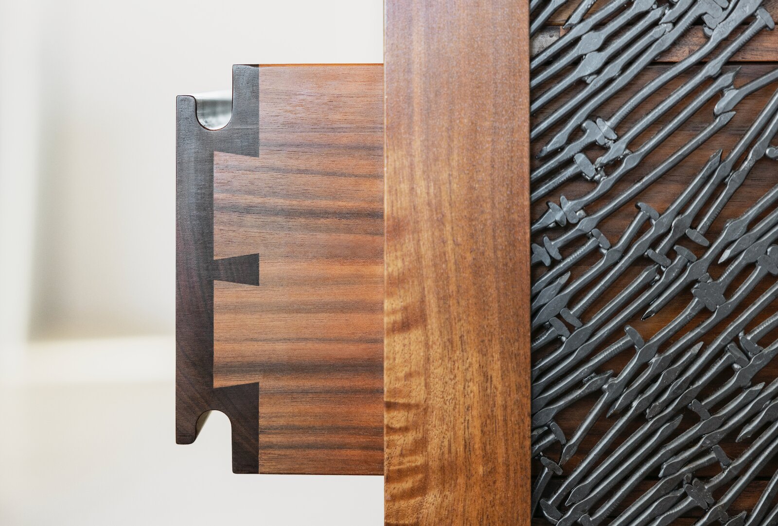 Local artist John Bisbee created a decorative screen out of nails for the end of the base cabinet. Stuart built the drawers using traditional wood-on-wood slides and proportionally spaced dovetails, which operate differently in summer and winter. 