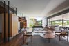 Modern home with Living Room, Bench, Bookcase, Coffee Tables, Chair, Sofa, Pendant Lighting, Gas Burning Fireplace, and Dark Hardwood Floor. living room Photo 4 of Pindaibeiras House