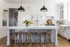 Modern home with Kitchen, Refrigerator, Medium Hardwood Floor, Drop In Sink, Pendant Lighting, and Dishwasher. Kirsten Krason of House of Jade designed her chic kitchen with Big Chill appliances including the Classic Fridge in White with Satin Nickel trim, the Classic Dishwasher in White with Brushed Brass trim and the 36" Classic Stove in Custom Basalt Gray with Brushed Brass trim. Photo of Stunning Kitchen Renovation by House of Jade