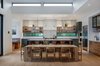 Modern home with Kitchen, Engineered Quartz Counter, Pendant Lighting, Colorful Cabinet, Wall Oven, Wood Cabinet, Ceramic Tile Backsplashe, Medium Hardwood Floor, Recessed Lighting, Refrigerator, and Undermount Sink. Kitchen & Dining Area with Clerestory Photo 11 of Vancouver Island Residence